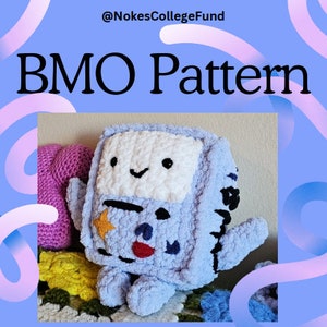 Op de afbeelding: Een gehaakt blauw en wit BMO pluche speelgoed van de cartoon Adventure Time. Het speelgoed zit op een gehaakt deken. De afbeelding bevat de tekst "@NokesCollegeFund BMO Pattern".