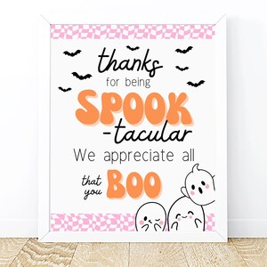 May include: A framed Halloween-themed print with the words "thanks for being SPOOK-tacular". The print features bats, ghosts, and a pink and white checkered border. The text is in black and orange.