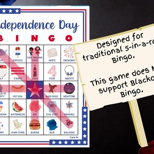 May include: Independence Day Bingo game card with red, white, and blue patriotic themed images. The card includes images of fireworks, the Statue of Liberty, and a hot dog. A sign states the game is designed for traditional 5-in-a-row Bingo.