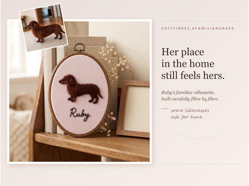 May include: An oval wooden embroidery hoop containing a light pink fabric background with a dark brown needle-felted dachshund silhouette and the name Ruby embroidered in black script. A small photo of a brown dachshund is attached to the top left.