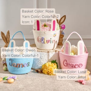 Pu&ograve; includere: Tre cesti pasquali in rosa, azzurro e bianco, ciascuno con dettagli di orecchie di coniglio. I cesti hanno manici e sono personalizzati con nomi in filato colorato. I cesti sono riempiti con materiale di riempimento decorativo.