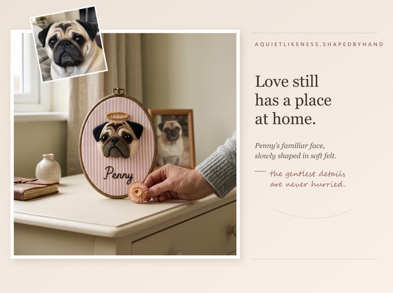 May include: An oval embroidery hoop containing a needle-felted pug portrait with a halo, mounted on pink and white striped fabric. The name Penny is embroidered below the pug. Text on the right reads: Love still has a place at home.