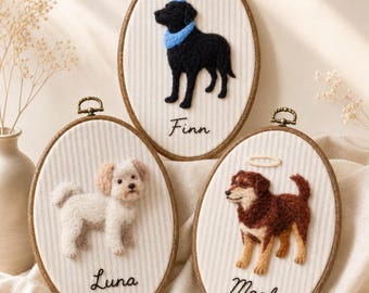 Könnte beinhalten: Drei ovale Stickrahmen mit nadelgefilzten Hunden auf weißem, fein gestreiftem Stoff. Ein schwarzer Hund namens Finn trägt einen blauen Partyhut und Schal. Ein weißer Hund namens Luna. Ein brauner Hund namens Maple mit einem weißen Heiligenschein darüber.