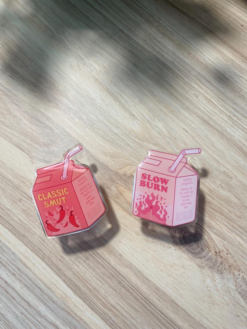 May include: Two clear plastic juice box stickers with pink and white text. The first sticker says "Classic Smut" with a red chili pepper design. The second sticker says "Slow Burn" with a red flame design.