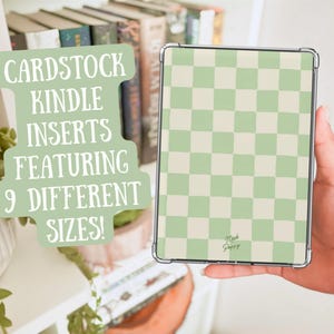 May include: A Kindle held in a hand, featuring a light green and cream checkerboard pattern. The text on a sign reads "Cardstock Kindle Inserts Featuring 9 Different Sizes!" The Kindle has a clear protective case. The brand name "Made Poppy" is visible.