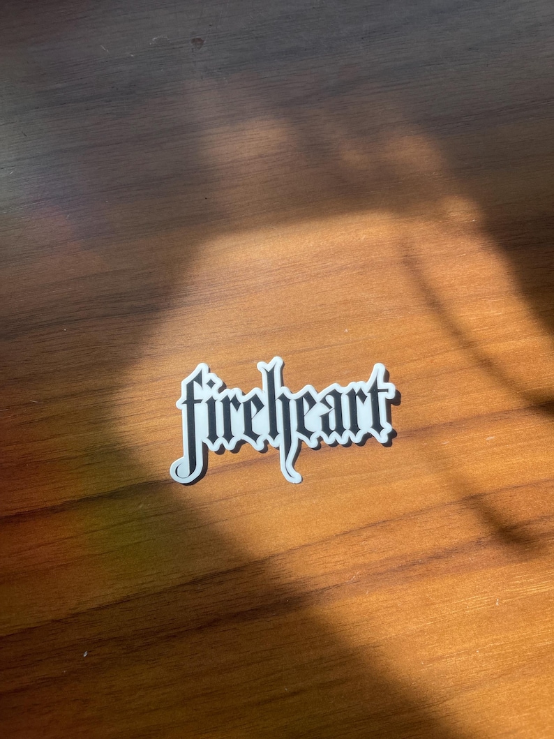 May include: A white sticker with the word "fireheart" written in black gothic lettering.