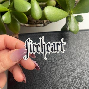 May include: White sticker with the word "fireheart" written in black gothic font.