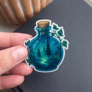 May include: A blue glass bottle with a cork stopper, filled with a swirling green and blue liquid. The bottle is surrounded by green ivy vines and the liquid contains a depiction of a forest scene with trees and a stream.