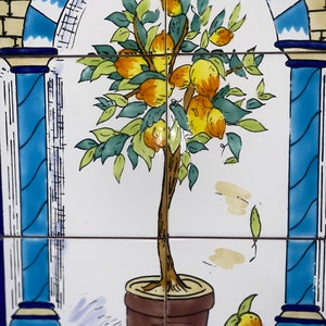 Könnte beinhalten: Dekorative Fliesenserie mit einem Zitronenbaum in einem braunen Topf, mit gelben Zitronen und grünen Blättern. Das Design ist vor einem weißen Hintergrund mit blauen und beigen dekorativen Elementen gehalten, was eine mediterrane Ästhetik erzeugt.
