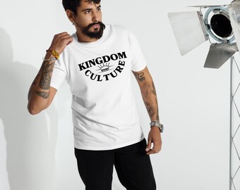 Könnte beinhalten: Weißes T-Shirt mit dem Text "KINGDOM over CULTURE" in Schwarz, gewölbt über einem kleinen Krönchen. Das T-Shirt wird von einer Person getragen, die eine schwarze Hose trägt. Im Hintergrund befindet sich ein Studiolicht.