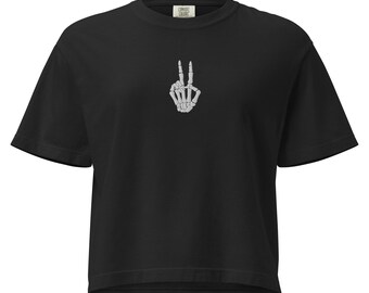 Może przedstawiać: Czarny t-shirt z białą szkieletową dłonią pokazującą znak pokoju. Koszulka ma krótkie rękawy i okrągły dekolt. Logo Comfort Colors jest widoczne na górnej części pleców.