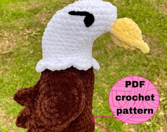 May include: Crochet pattern for a bald eagle amigurumi. The eagle is brown and white with a yellow beak. The pattern is available as a PDF download.