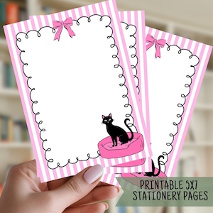 May include: Printable 5x7 stationery pages with a pink and white striped border and a black cat on a pink bed. Each page has a black curly border and a pink bow at the top. The text "Printable 5x7 Stationery Pages" is at the bottom.