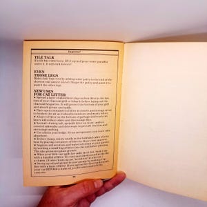 May include: Open book page with text titled "TILE TALK" and "NEW USES FOR CAT LITTER". The text provides tips for home improvement and cleaning, including using cat litter for various purposes. The page is yellowed with age.