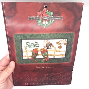 May include: A Christmas-themed craft pattern book with a red and green color scheme. The cover features a decorative wreath and the text "When Friends Gather." The interior image shows Christmas stockings and a fence.