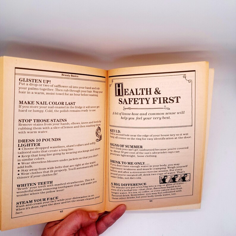 May include: Open book with pages displaying text about beauty basics and health tips. The left page lists tips like making nail color last and whitening teeth. The right page has a headline: Health & Safety First.