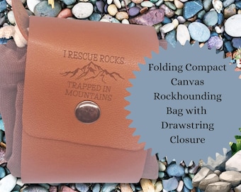 Puede incluir: Una bolsa de lona marrón para la búsqueda de rocas con cierre de cordón. La bolsa tiene una solapa de cuero con el texto "I Rescue Rocks Trapped In Mountains" y un gráfico de montaña.