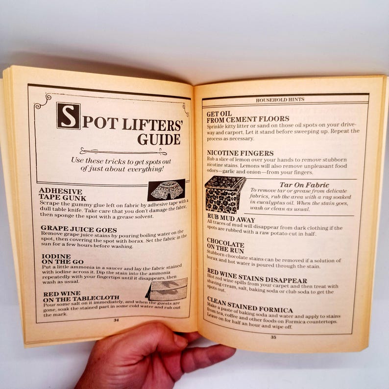 May include: An open book with a guide titled "Spot Lifters' Guide" offering tips for removing stains. The pages are yellowed, and the text is in black. The guide includes instructions for various stains.
