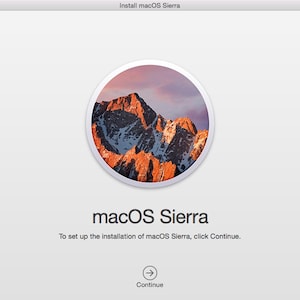 May include: A screen shot of the macOS Sierra installation process. The screen shows a mountain range with a sunset sky in the background. The text "Install macOS Sierra" is at the top of the screen. The text "macOS Sierra" is in a large font in the center of the screen. The text "To set up the installation of macOS Sierra, click Continue." is below the large font text. The text "Continue" is below the text and an arrow points to the right.