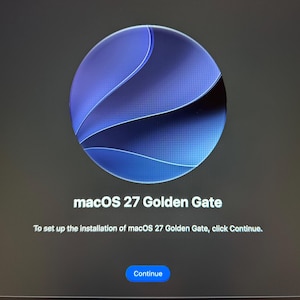 May include: A digital screen display showing the macOS 27 Golden Gate installation interface. A large blue circular icon with abstract wave patterns sits above the text macOS 27 Golden Gate and a prompt to click Continue to proceed with setup.