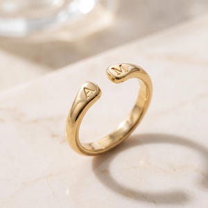 A breathtakingly elegant adjustable initial ring designed to combine modern versatility with deeply personalized meaning. This stunning 925 sterling silver piece features a sleek, open-cuff design with your choice of two custom-engraved letters on each resting end. Whether you are keeping a loved one's initial close to your own, representing your children, or looking for the perfect everyday signature piece, this wrap ring is the ultimate bespoke accessory.