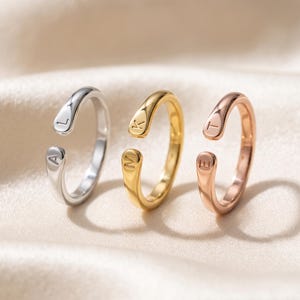 A breathtakingly elegant adjustable initial ring designed to combine modern versatility with deeply personalized meaning. This stunning 925 sterling silver piece features a sleek, open-cuff design with your choice of two custom-engraved letters on each resting end. Whether you are keeping a loved one's initial close to your own, representing your children, or looking for the perfect everyday signature piece, this wrap ring is the ultimate bespoke accessory.