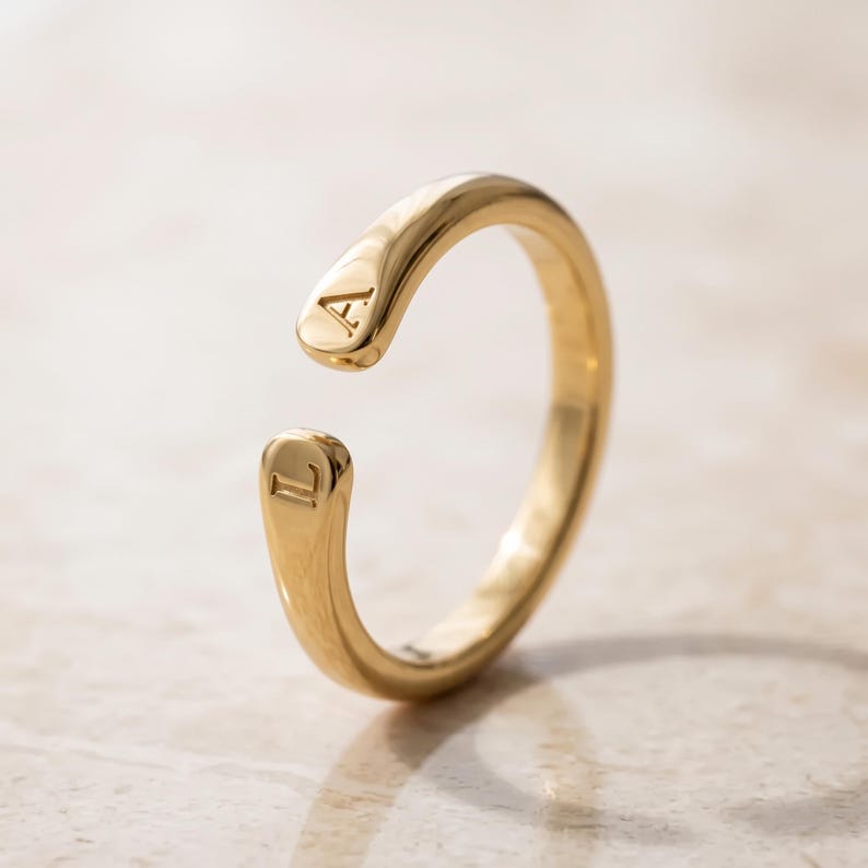 A breathtakingly elegant adjustable initial ring designed to combine modern versatility with deeply personalized meaning. This stunning 925 sterling silver piece features a sleek, open-cuff design with your choice of two custom-engraved letters on each resting end. Whether you are keeping a loved one's initial close to your own, representing your children, or looking for the perfect everyday signature piece, this wrap ring is the ultimate bespoke accessory.