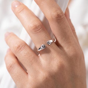 A breathtakingly elegant adjustable initial ring designed to combine modern versatility with deeply personalized meaning. This stunning 925 sterling silver piece features a sleek, open-cuff design with your choice of two custom-engraved letters on each resting end. Whether you are keeping a loved one's initial close to your own, representing your children, or looking for the perfect everyday signature piece, this wrap ring is the ultimate bespoke accessory.