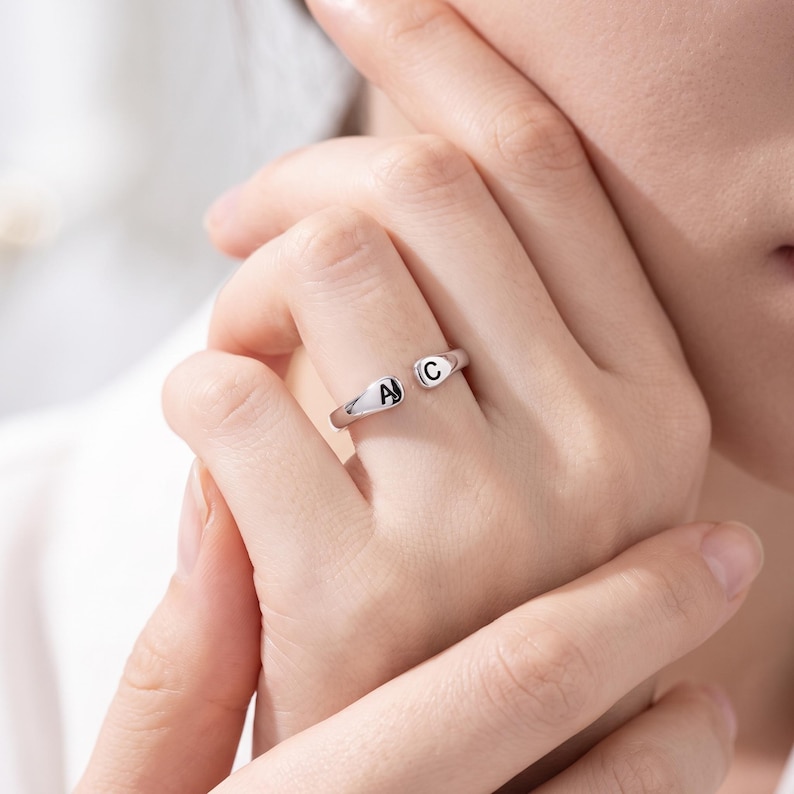 A breathtakingly elegant adjustable initial ring designed to combine modern versatility with deeply personalized meaning. This stunning 925 sterling silver piece features a sleek, open-cuff design with your choice of two custom-engraved letters on each resting end. Whether you are keeping a loved one's initial close to your own, representing your children, or looking for the perfect everyday signature piece, this wrap ring is the ultimate bespoke accessory.