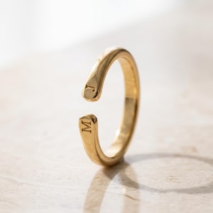 A breathtakingly elegant adjustable initial ring designed to combine modern versatility with deeply personalized meaning. This stunning 925 sterling silver piece features a sleek, open-cuff design with your choice of two custom-engraved letters on each resting end. Whether you are keeping a loved one's initial close to your own, representing your children, or looking for the perfect everyday signature piece, this wrap ring is the ultimate bespoke accessory.