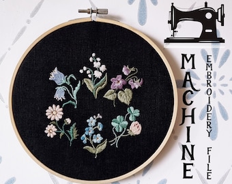 May include: A black embroidery hoop with a variety of colourful flowers embroidered on black fabric. The text "MACHINE EMBROIDERY FILE" and "BY COZYCOTTAGE STITCHES" is visible below the hoop.