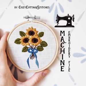 May include: A hoop embroidery design featuring a bouquet of three yellow sunflowers with green leaves and a blue ribbon. The design is in a wooden embroidery hoop. The text "MACHINE EMBROIDERY FILE" is written vertically on the right side of the image.