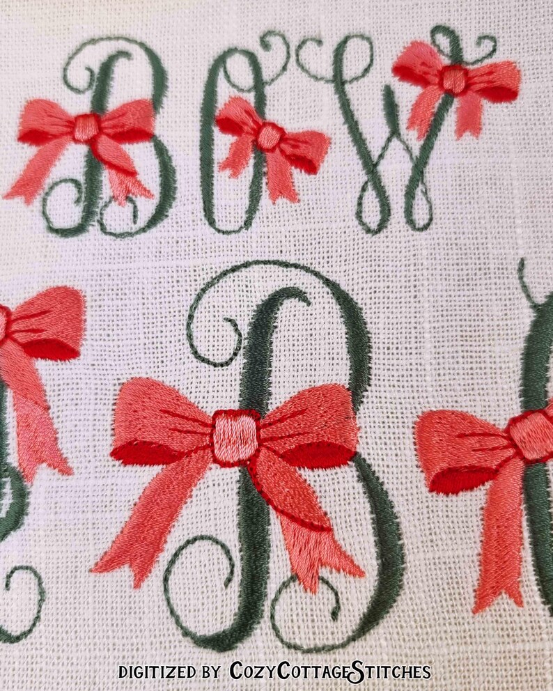 May include: Embroidered design of the word "BOY" with a green outline and pink bows. The text "DIGITIZED BY COZYCOTTAGE STITCHES" is at the bottom of the image.