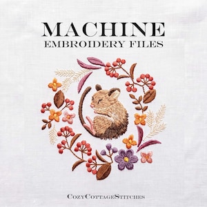 May include: Machine embroidery files featuring a central brown mouse curled within a circular wreath of orange, purple, and pink flowers, brown leaves, and red berries. The text reads MACHINE EMBROIDERY FILES at the top and CozyCottageStitches at the bottom.
