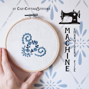 May include: A blue and white floral embroidery design in a hoop. The design is for a machine embroidery file. The text "MACHINE EMBROIDERY FILE" is on the right side of the image.