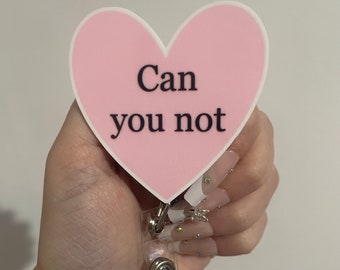 May include: Pink heart-shaped badge holder with the text "Can you not" in black lettering.
