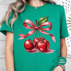a woman wearing a green shirt with cherries on it