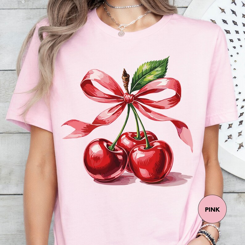 a woman wearing a pink shirt with cherries on it