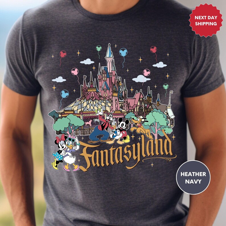 a man wearing a disneyland shirt with a castle in the background