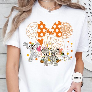 a woman wearing a white mickey mouse shirt