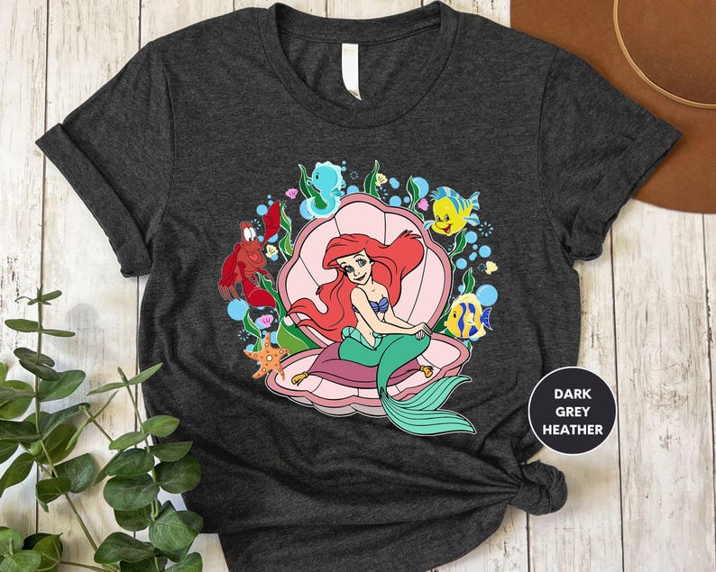a t - shirt with a mermaid sitting on top of it
