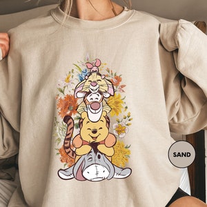 a woman wearing a sweatshirt with winnie the pooh on it