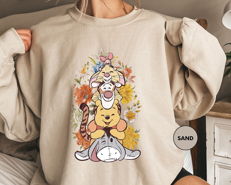 a woman wearing a sweatshirt with winnie the pooh on it