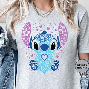 a woman wearing a t - shirt with a cartoon character on it