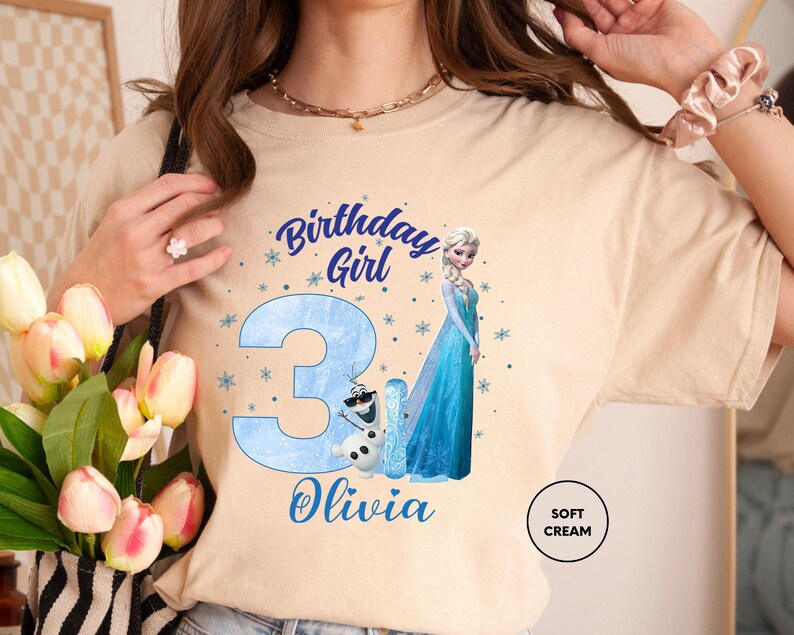 a woman in a birthday shirt holding a bouquet of tulips