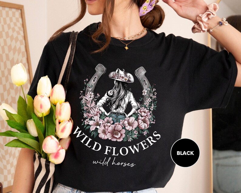 a woman wearing a black wild flowers t - shirt