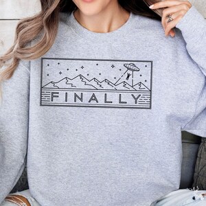 a woman wearing a sweatshirt with a graphic on it