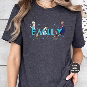 A person wearing a gray t-shirt with a graphic design featuring characters from the Disney movie Frozen.