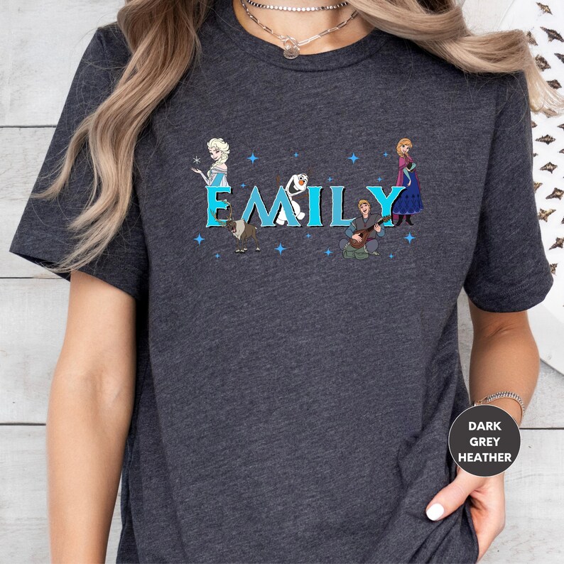 A person wearing a gray t-shirt with a graphic design featuring characters from the Disney movie Frozen.