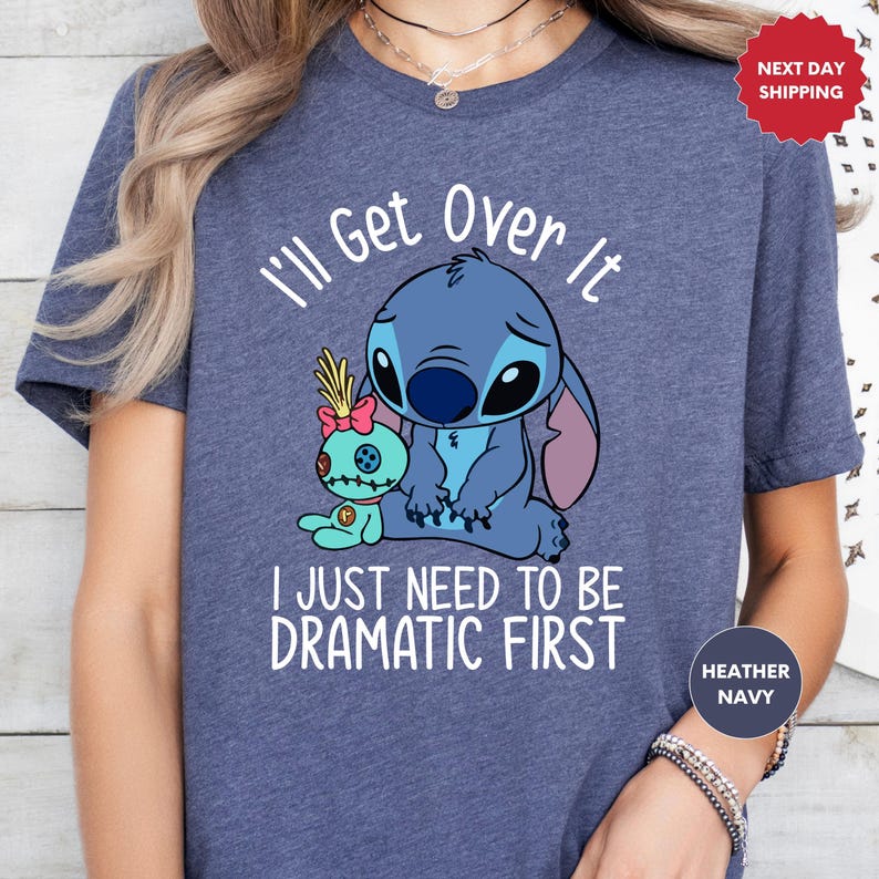 A person wearing a blue t-shirt with a cartoon character and text printed on it.